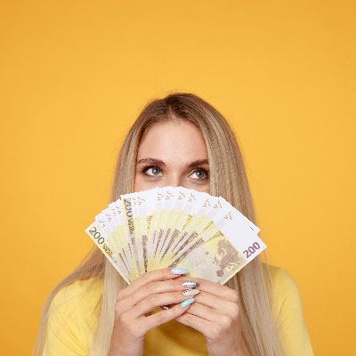 jeune femme tenant des billets devant son visage